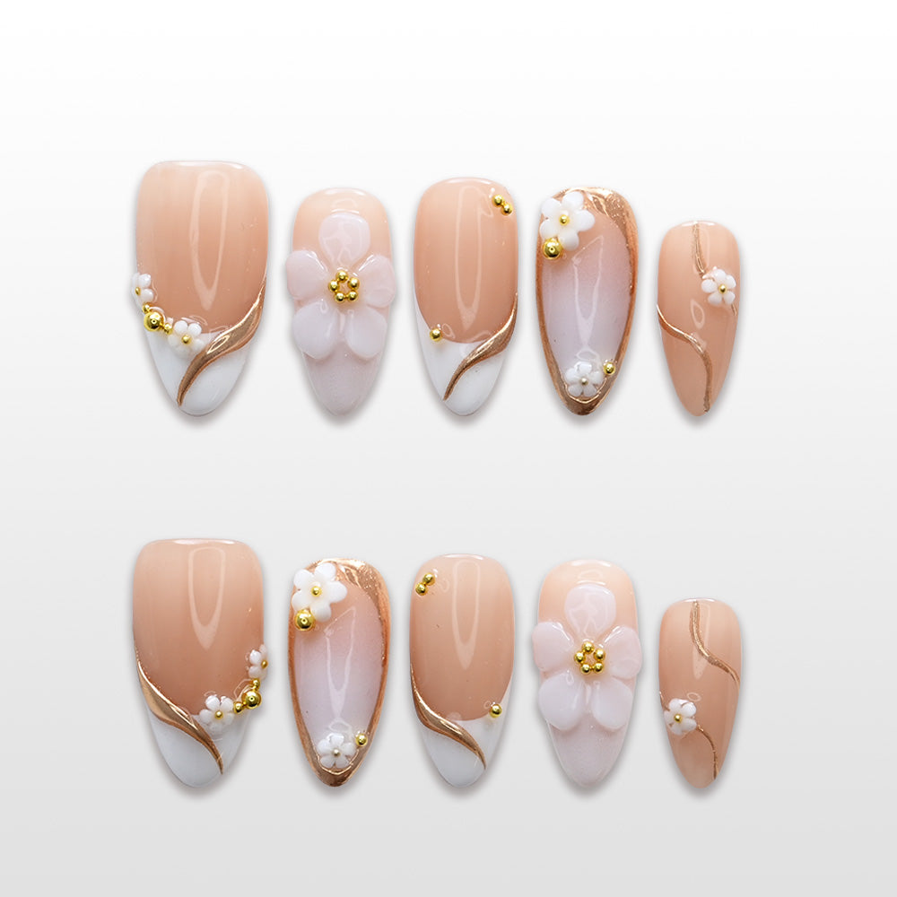Nude French tip press-on nails with white 3D flowers and gold bead accents