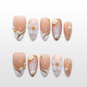 Nude French tip press-on nails with white 3D flowers and gold bead accents