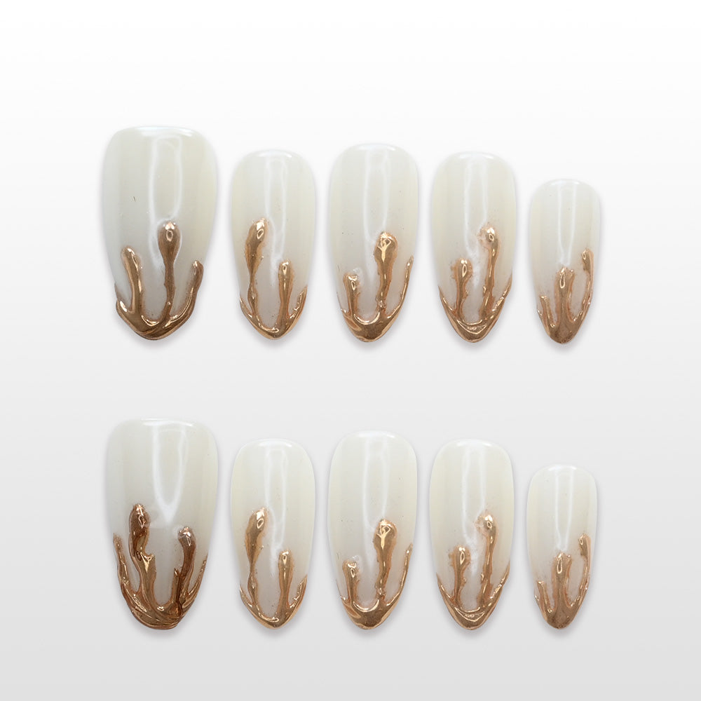 Milky white press-on nails with molten gold 3D drip design and glossy finish