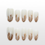 Milky white press-on nails with molten gold 3D drip design and glossy finish