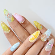 Multi-color press-on nails with hand-sculpted flowers, gradient tones, and sparkle