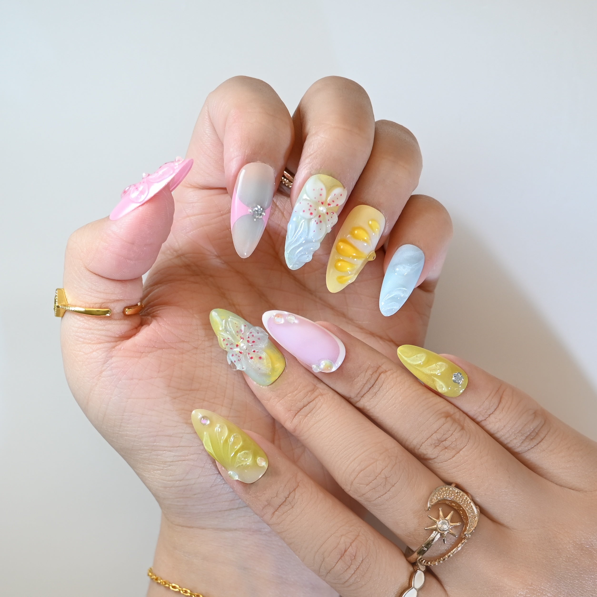 Cute pastel press-on nails with yellow petals, pink flowers, and crystal accents