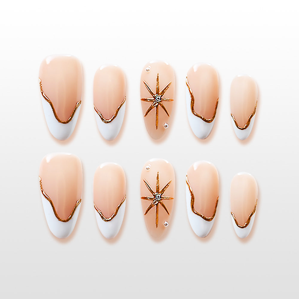 Nude and white French tip press-on nails with gold wavy lines and crystal star design