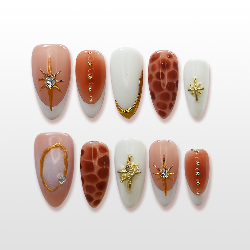 Luxury star-themed press-on nails with 3D gold charms and marble-like patterns