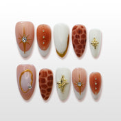 Luxury star-themed press-on nails with 3D gold charms and marble-like patterns