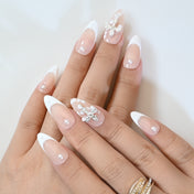 Minimalist nude press-on nails with white French tips, pearls, and crystal cross