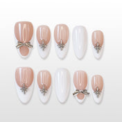 Nude and white French press-on nails with silver bow charm and star embellishments