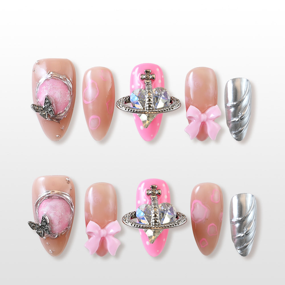 Pink and nude press-on nails with 3D butterfly, planet charm, and silver swirl