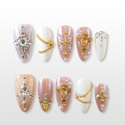 Gold angel and star press-on nails with pearl accents and chain details