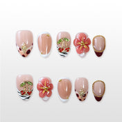 Nude press-on nails with red cherry rhinestones, zebra tips, and 3D floral accents