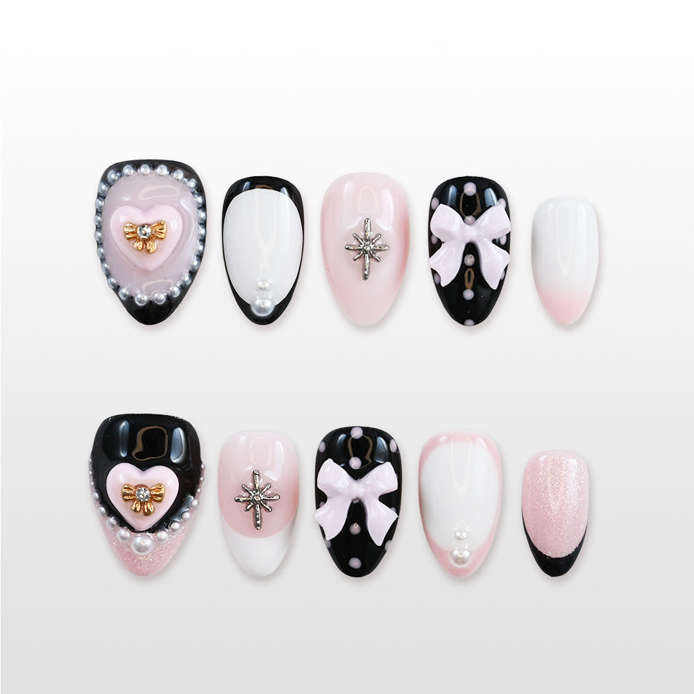 Black and pink press-on nails with 3D bows, heart charms, pearls, and star accents