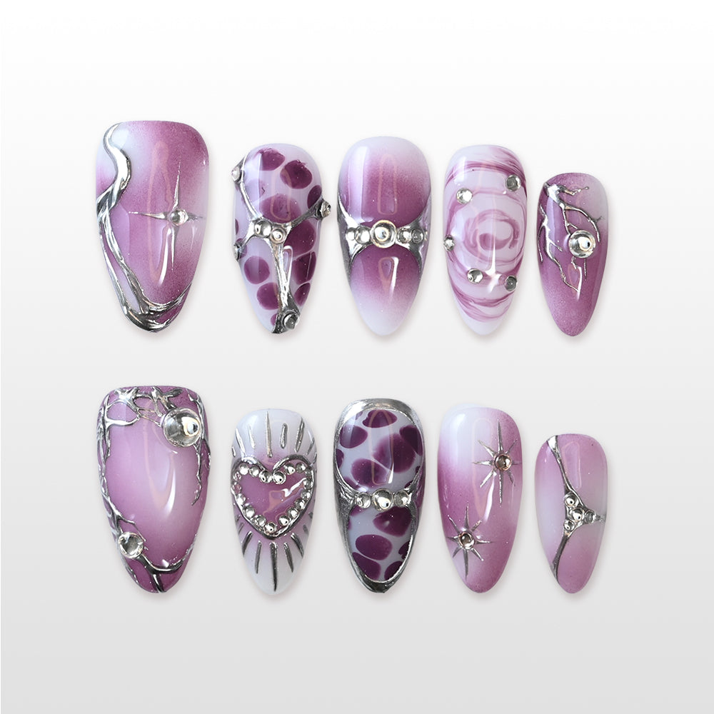 Metallic purple press-on nails with rhinestone heart, galaxy swirls, and chrome accents