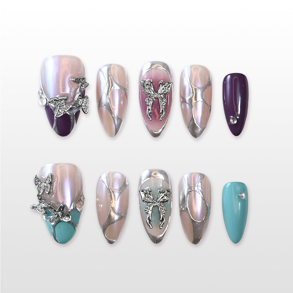 Iridescent silver and pink press-on nails with 3D butterfly charms and gemstone accents