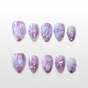 Luxury almond nails with metallic champagne base, floral centerpiece and gemstone details