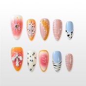 Handmade nails featuring orange ombré, blue accents and black leopard spots