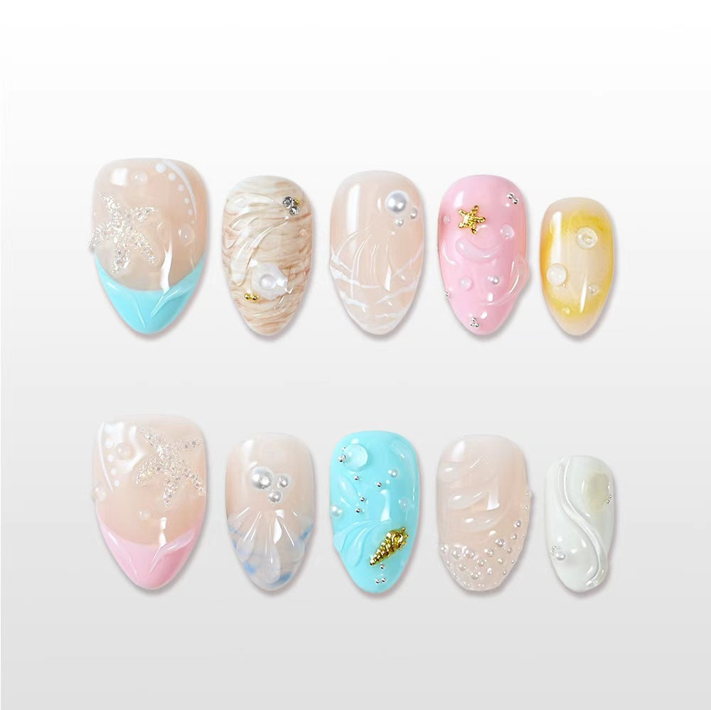 Handmade glossy nails featuring 3D seashell texture, gold star details and sea blue highlights