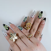Almond shaped nails with nude base, cat eye shimmer, and graphic black French accents