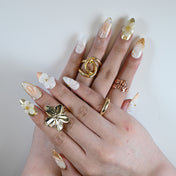 Elegant bridal-inspired almond nails featuring sculpted petals and glossy pearl finish
