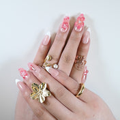 Natural nude nails with soft pink flower embellishments and glossy French manicure