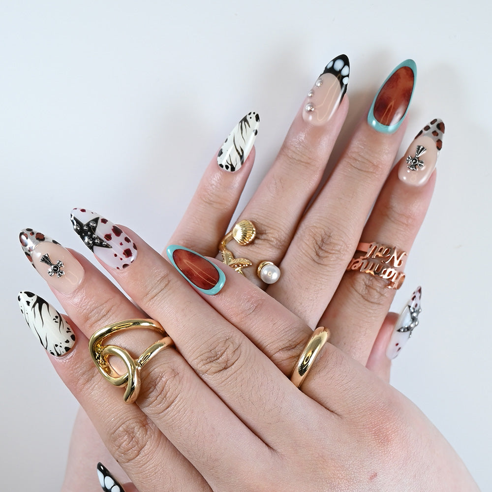 Medium almond-shaped press on nails styled with layered gold rings and bold motif mix