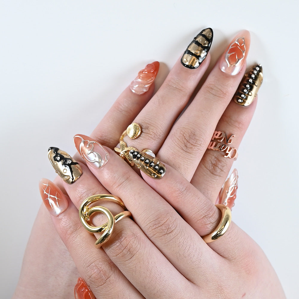 Luxury reusable nails with spiked silver beads, gold foil, and fluid gel textures