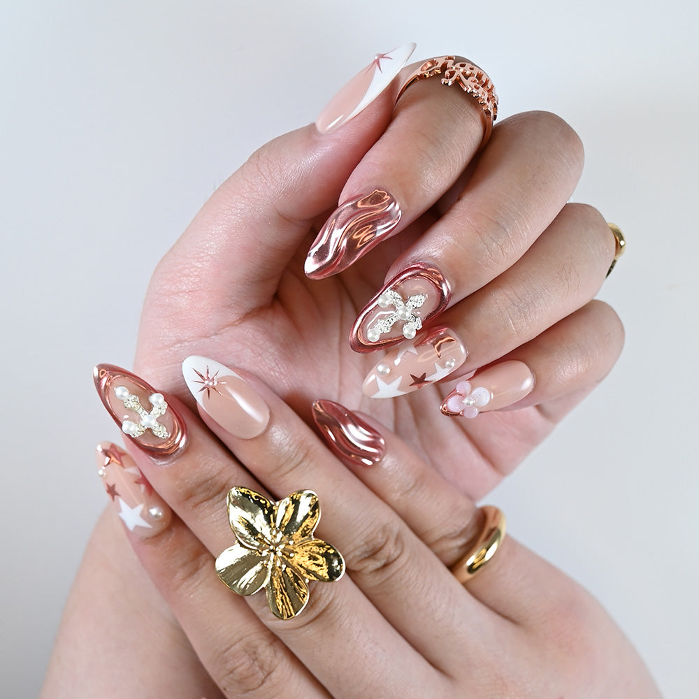 Luxury press on nail set in pink and nude tones with sculpted shapes and shiny pearl details
