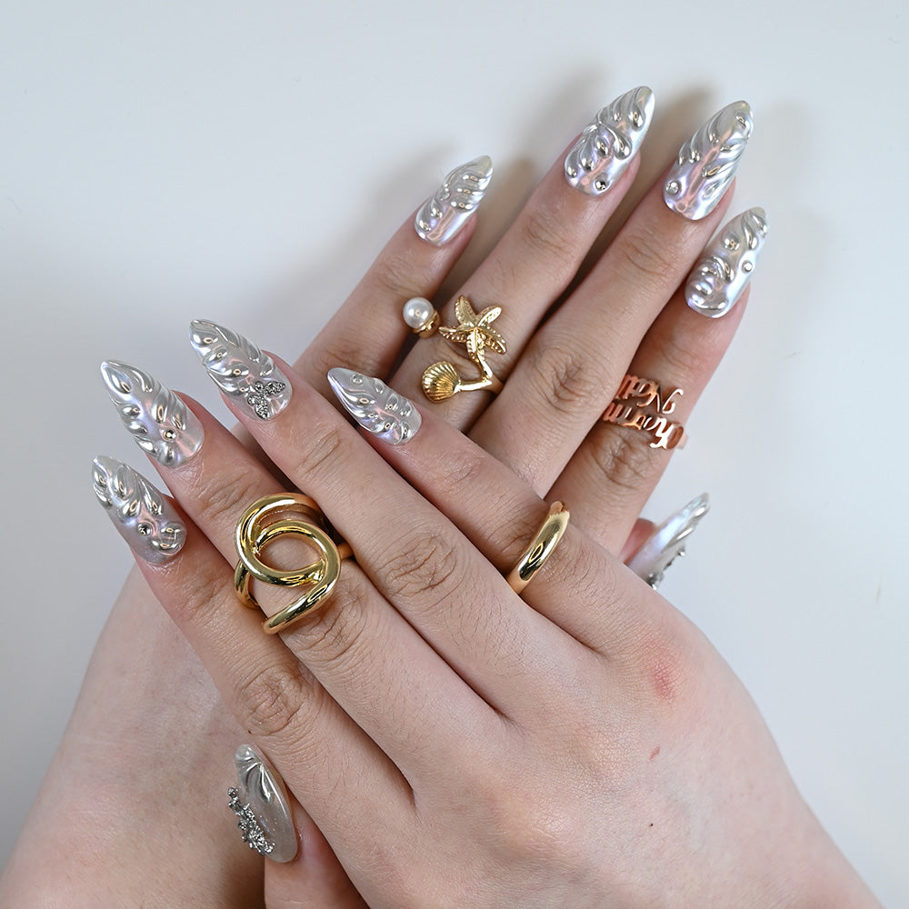 Futuristic mirror finish acrylic nails with glossy texture and nail art accents