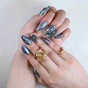 Charmeenail futuristic silver and purple nails styled with layered rings