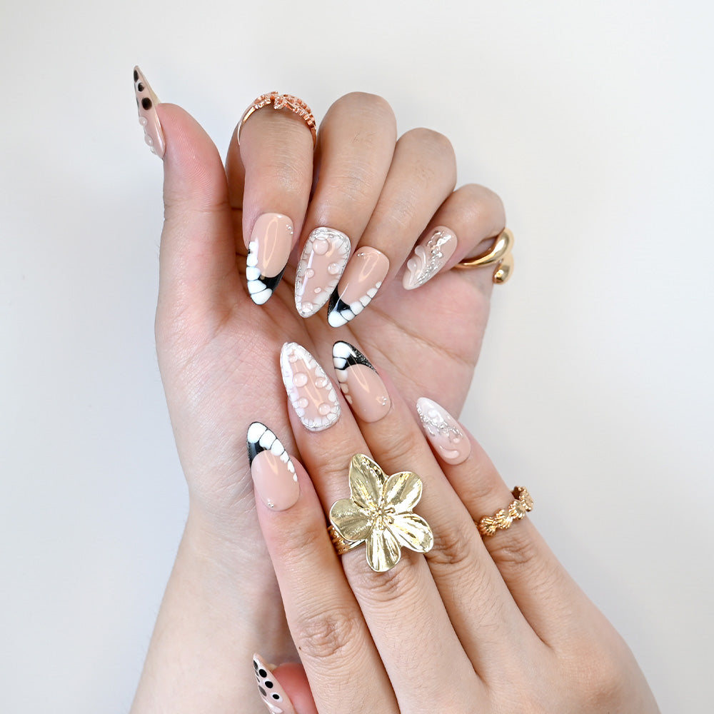 Almond nude nails with 3D bubble design, monochrome tips, and rhinestone details