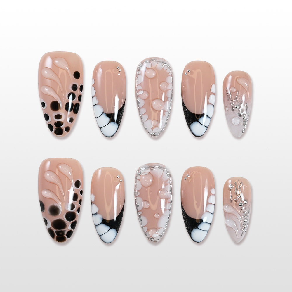 Nude press-on nails with black polka dots, bubble art, and silver foil accents