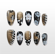 Medium almond press-on nails with black, gold, and grey 3D flowers, rhinestones, and polka dot accents