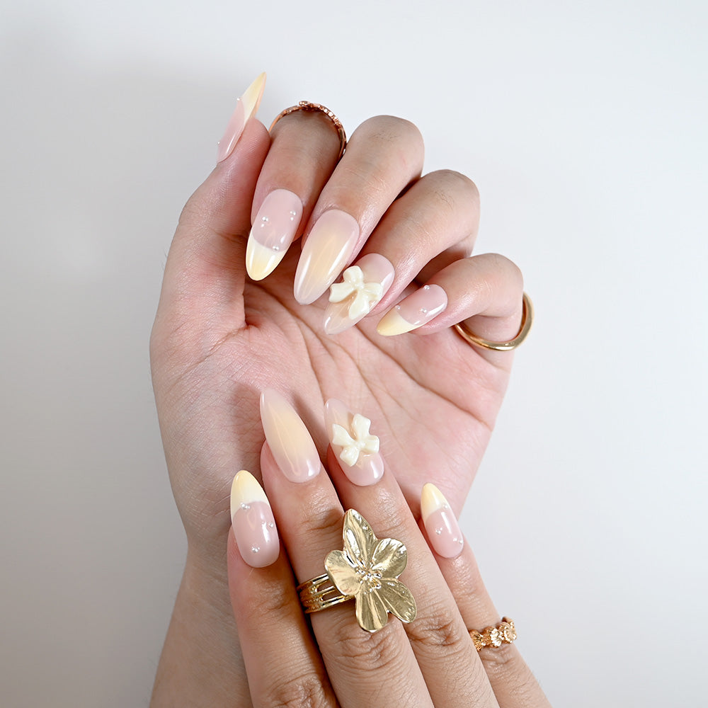 Elegant pastel ombre press-on nails with creamy bow and pearl embellishments