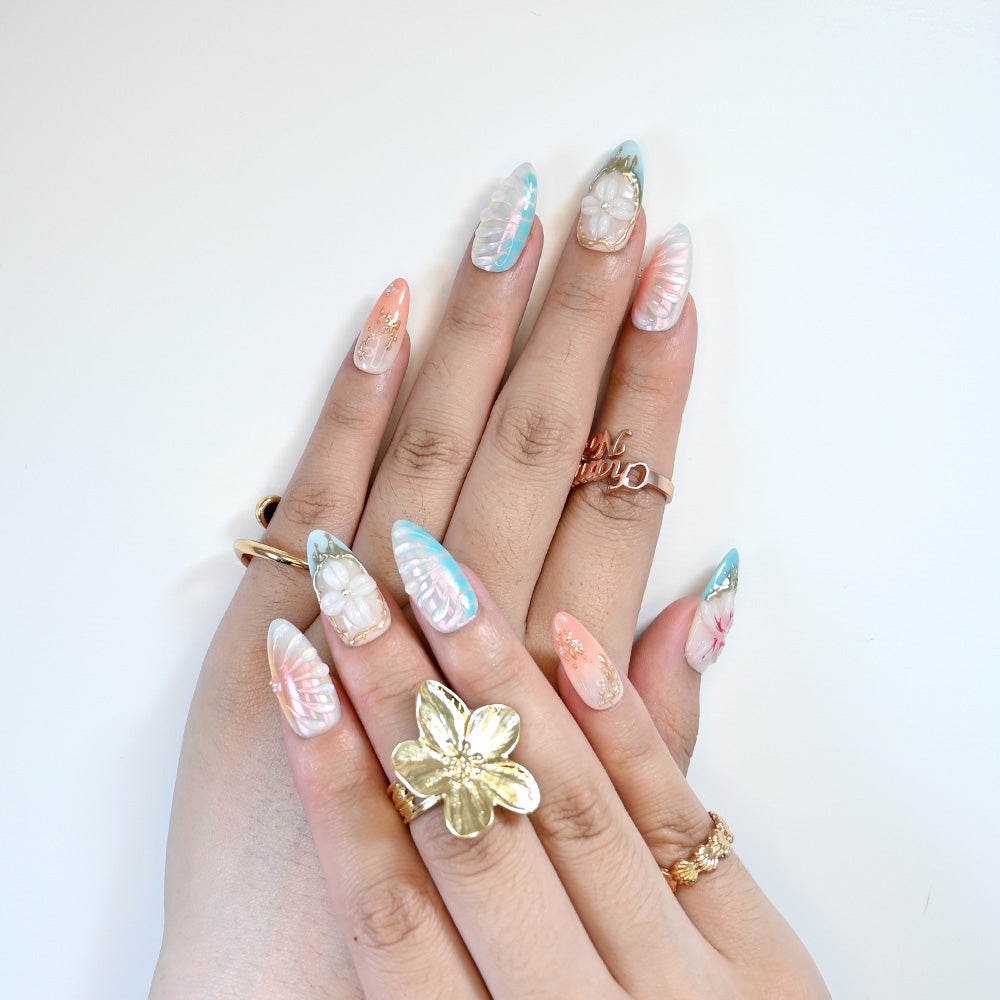 Beach theme press-on nails with shimmering shell patterns and luxury gold art