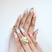 Beach theme press-on nails with shimmering shell patterns and luxury gold art