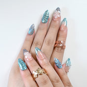 Handmade nude and teal press-on nails with seashell accents