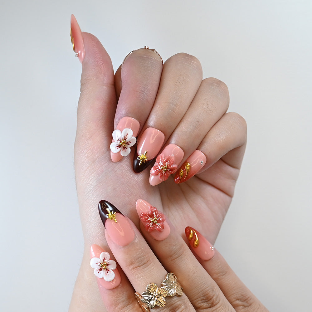 Handmade floral press-on nails with coral base and gold star design
