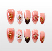 Coral pink press-on nails with 3D cherry blossom flowers and gold accents