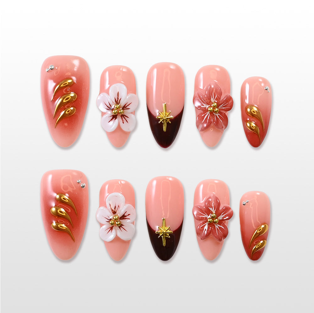 Coral pink press-on nails with 3D cherry blossom flowers and gold accents