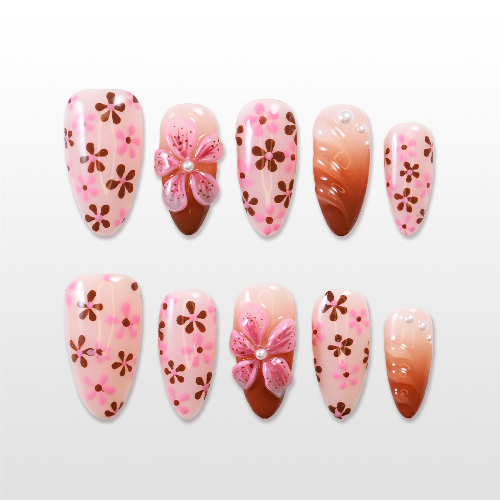 Pink press-on nails with brown floral pattern and 3D flower accent