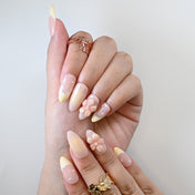 Handmade acrylic nails featuring soft nude gradient, pearls and floral embellishment