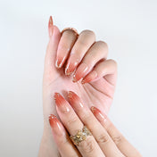 Reusable press-on nails in peachy nude with golden details