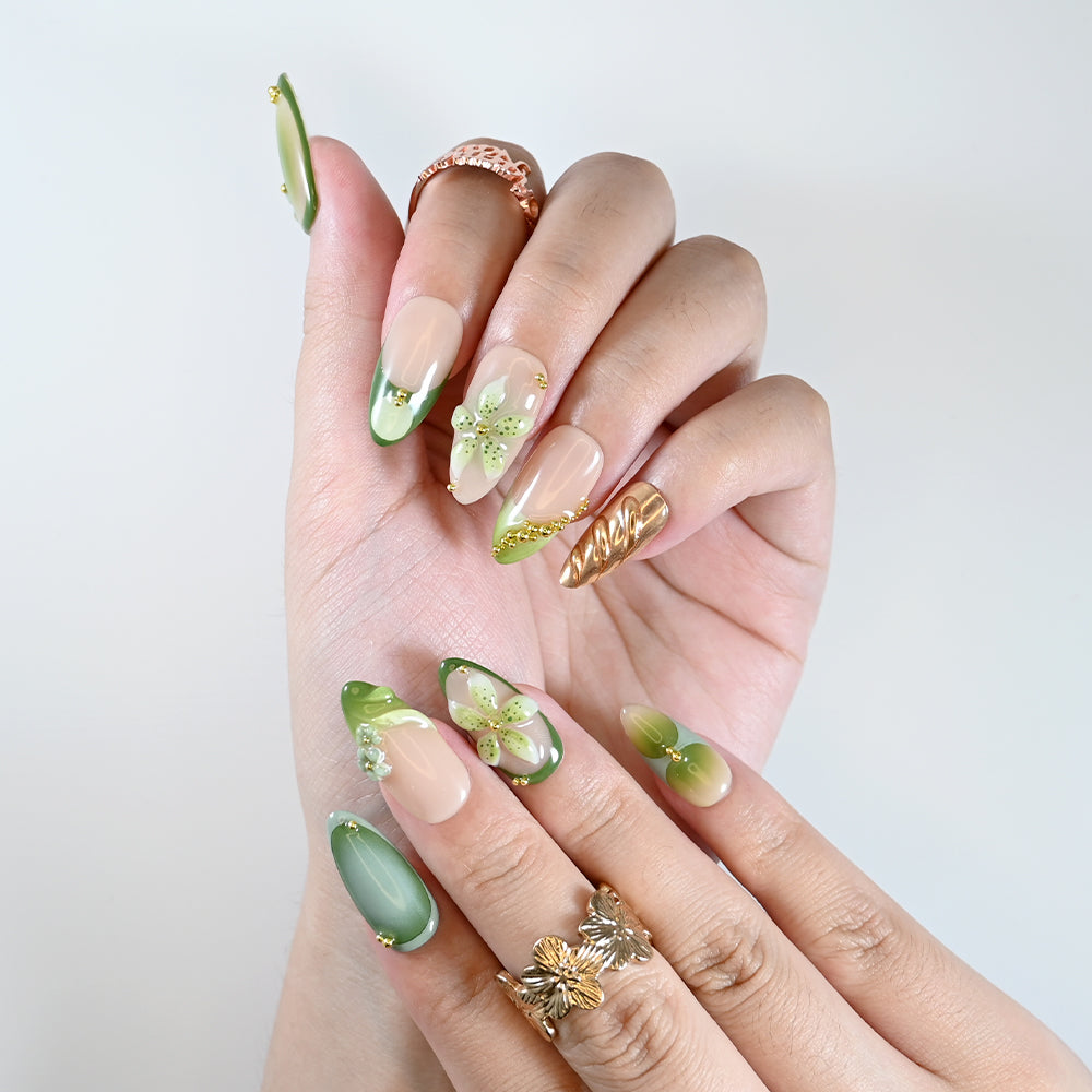 Handmade almond nails with emerald green, nude base, and floral design