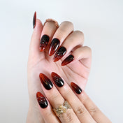 Reusable press-on nails with black-red fade and embossed floral accents