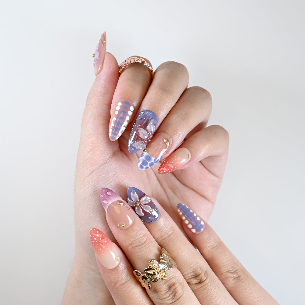 Handmade almond nails with lilac flower accents and nude ombre base