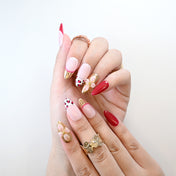 Luxury press-on nails with red, gold, and blush tones plus 3D blossoms