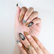 Handmade almond nails with metallic gold sculpted art and flower design