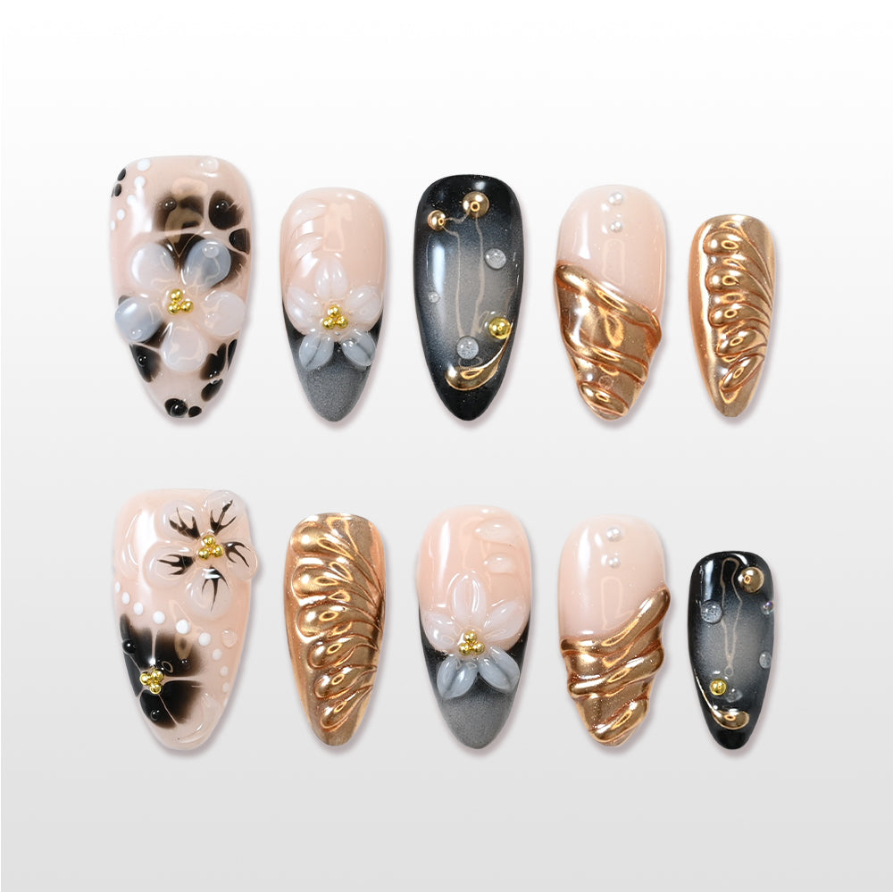 Black and gold press-on nails with 3D white floral accents
