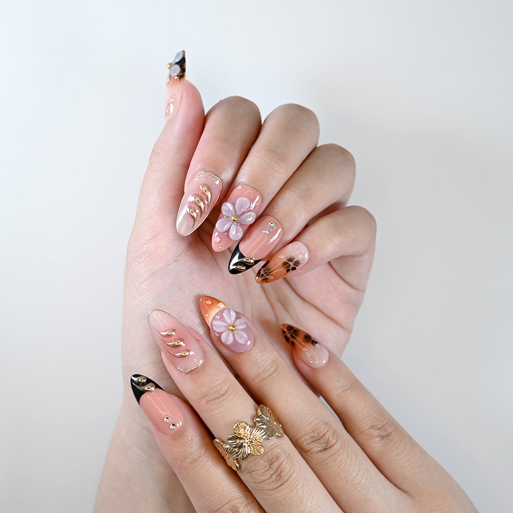 Handmade almond nails with metallic gold accents and floral design