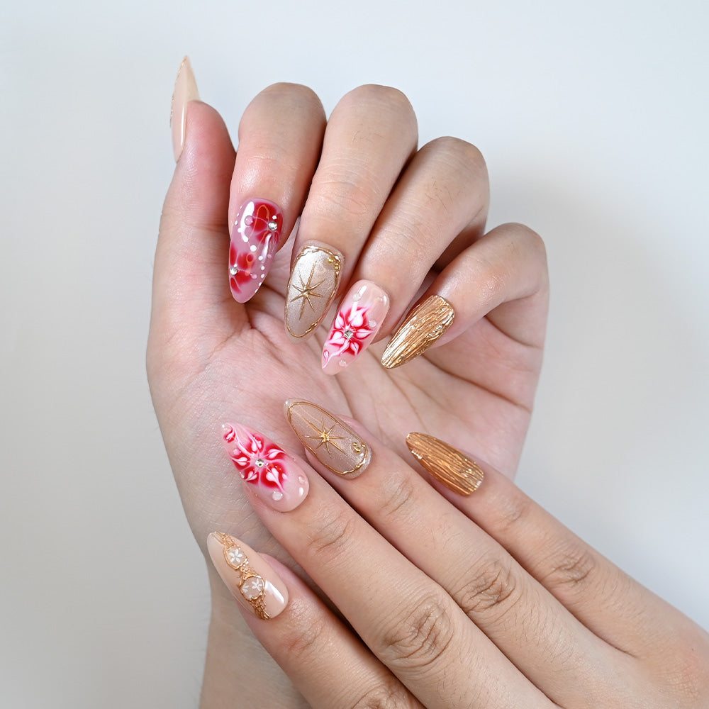 Medium almond reusable press-on nails with glossy red accents and gold shimmer