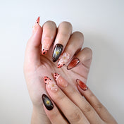 Medium almond reusable press-on nails with gradient pink tips and floral accents